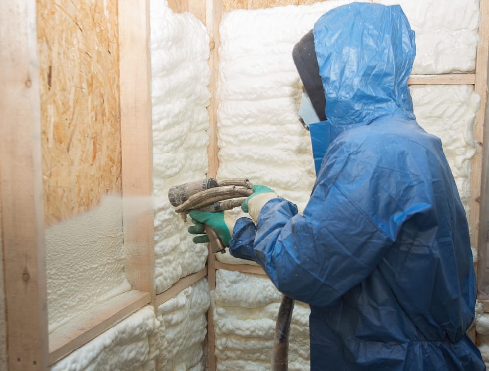 Un technicien en isolation uréthane qui giclé du polyuréthane dans un mur intérieur d'un bâtiment à Lévis